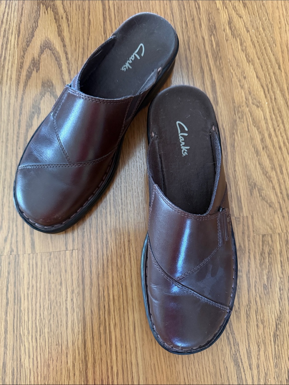Clarks slip-on mule clogs featuring a buckle detail
